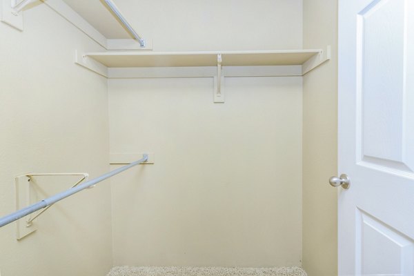 Walk-in closet in a cozy bedroom at Links at Legacy Ridge Apartments, offering ample storage space and convenience for residents