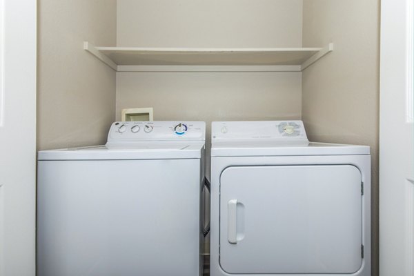Convenient laundry room with modern appliances at Links at Legacy Ridge Apartments, a luxury community by Greystar