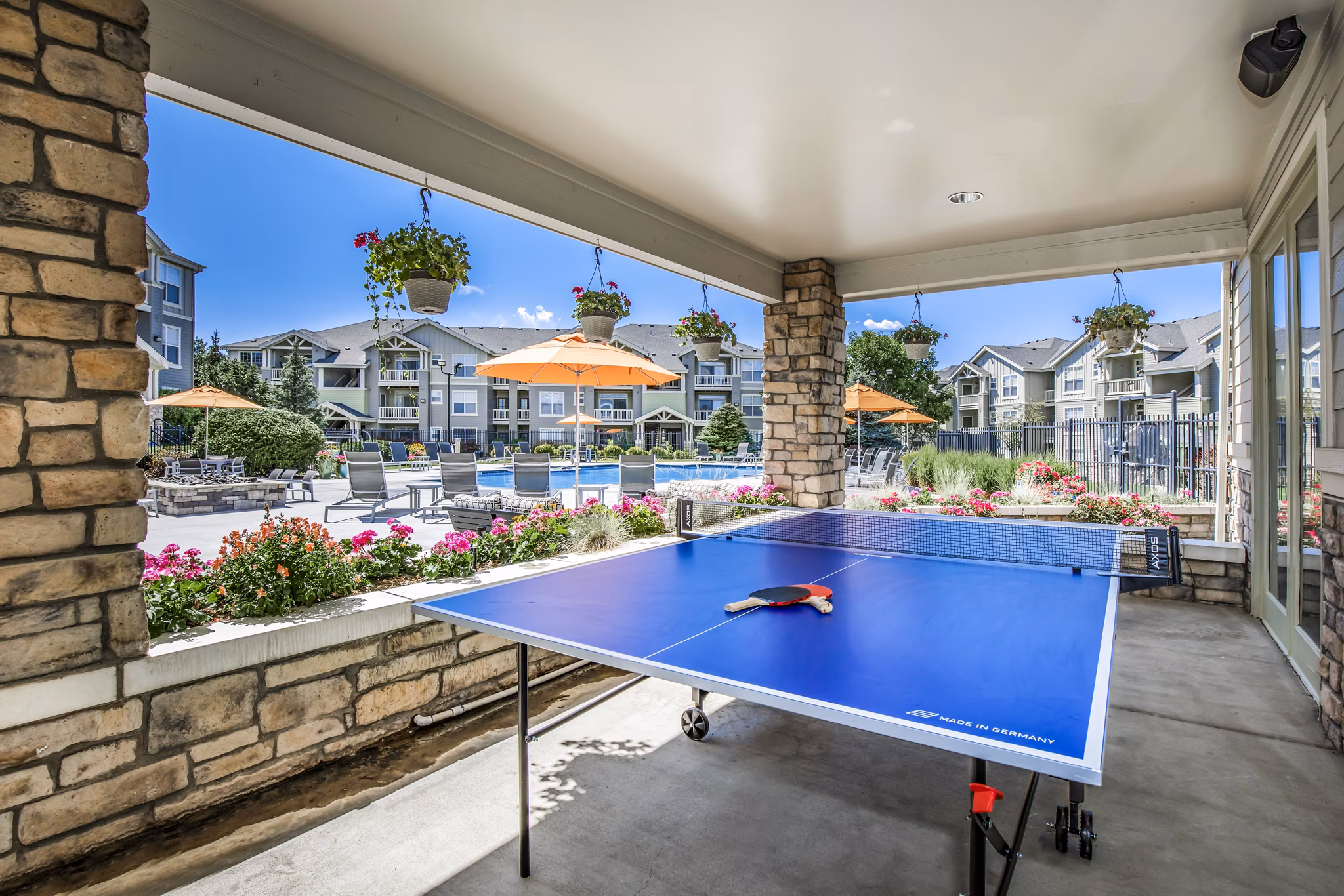 Patio with game area at Links at Legacy Ridge Apartments: Enjoy outdoor leisure and entertainment in our luxury community spaces