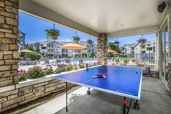 Patio with game area at Links at Legacy Ridge Apartments: Enjoy outdoor leisure and entertainment in our luxury community spaces