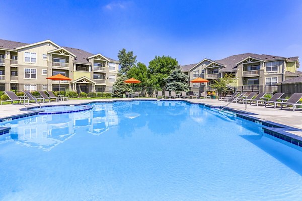 Outdoor swimming pool at Links at Legacy Ridge Apartments with loungers and parasols, an ideal spot for relaxation and recreation