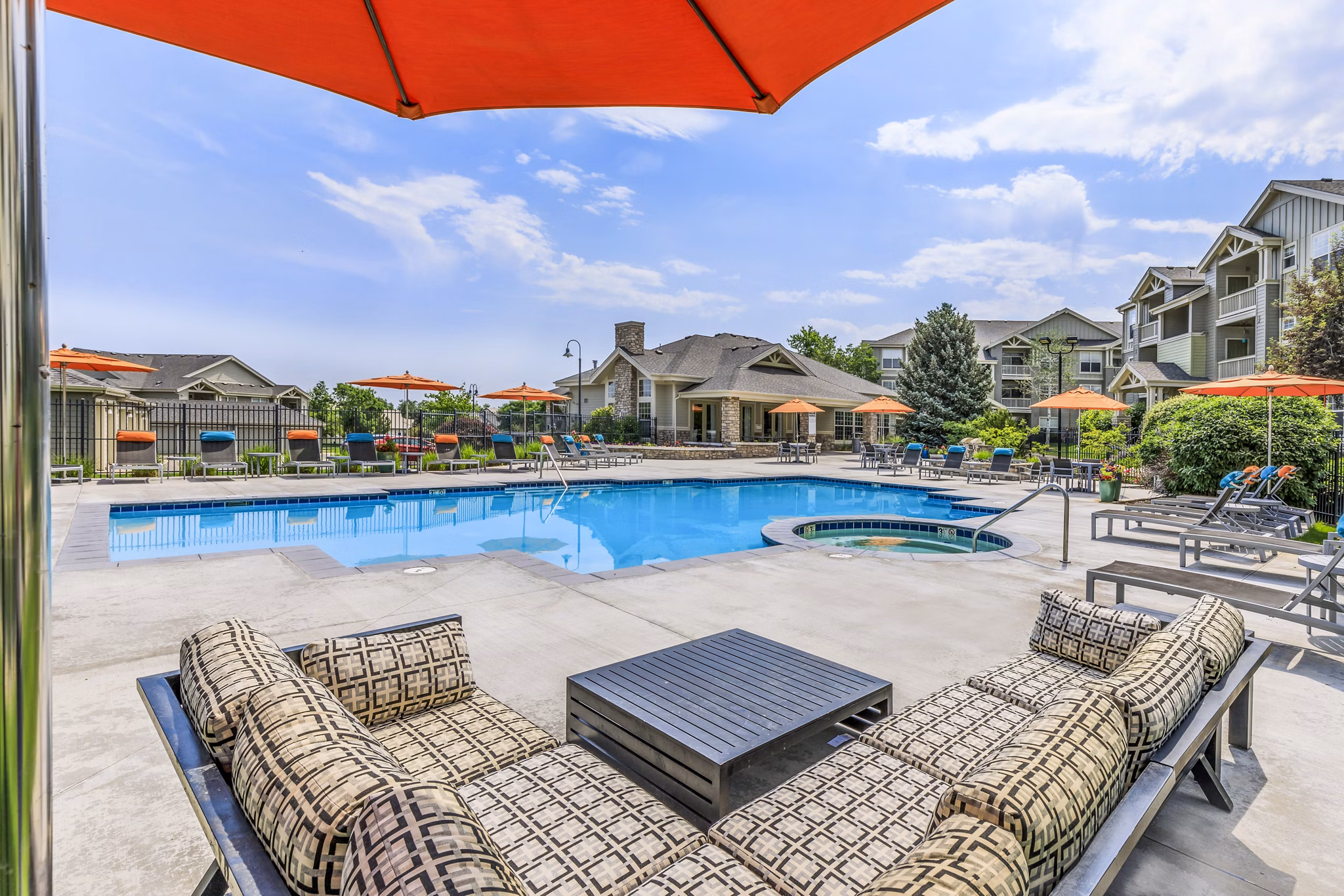 Outdoor pool oasis at Links at Legacy Ridge Apartments featuring luxurious seating and stunning landscaping for relaxation and entertainment