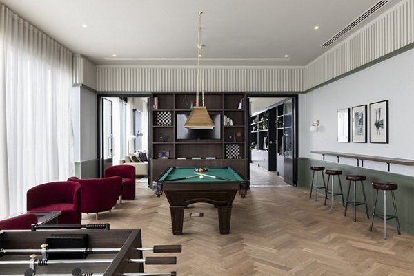 Spacious and stylish game room at Lyons Dock with a billiard table and elegant seating arrangements.