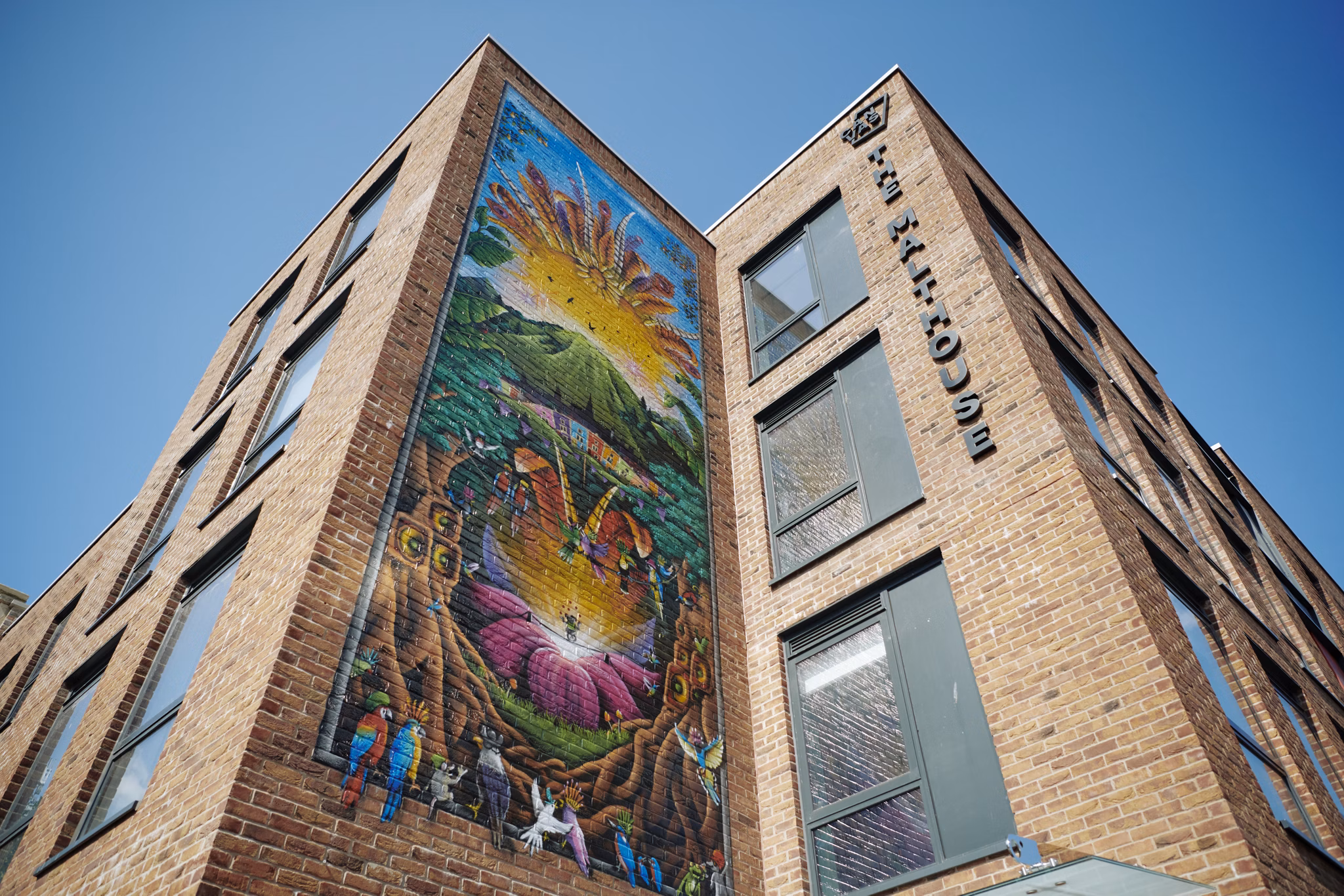 Exterior view of Canvas Bristol with striking architecture and a colorful mural decorating the building facade.