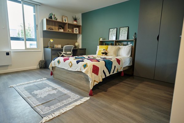 Stylish bedroom at Canvas Bristol with a vibrant color scheme, cozy bedding, and ample storage space.