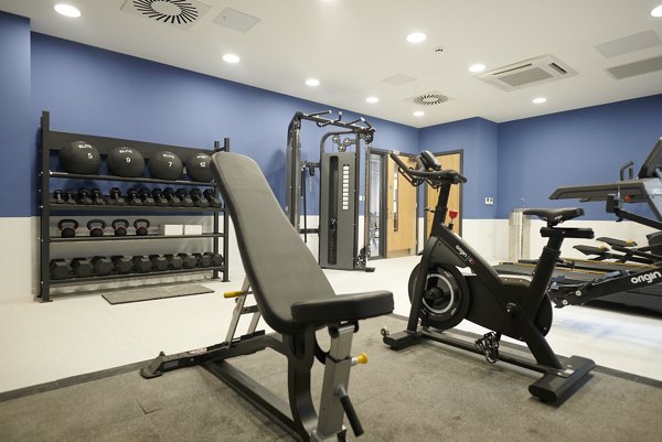 Fully equipped fitness room at Canvas Bristol with weights, cardio machines, and ample space for workouts.