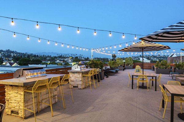 Outdoor grill station at Vue Los Feliz Apartments featuring modern barbeque facilities and seating area