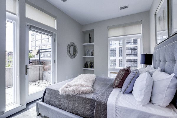 Cozy bedroom with modern decor at Brookland Press Apartments in Washington, DC, offering luxury living experiences