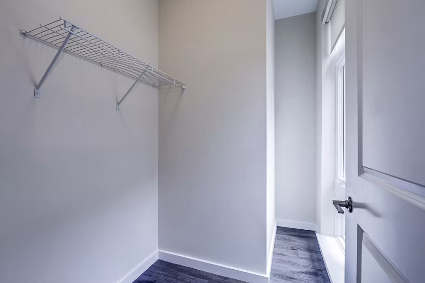 Walk-in bedroom closet with ample storage at Brookland Press Apartments in luxury Greystar property
