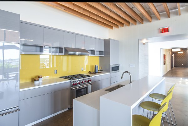 Clubhouse kitchen with modern appliances and seating at Brookland Press Apartments, offering a stylish and communal gathering space