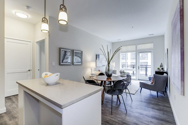 Dining room with modern lighting and stylish seating at Brookland Press Apartments