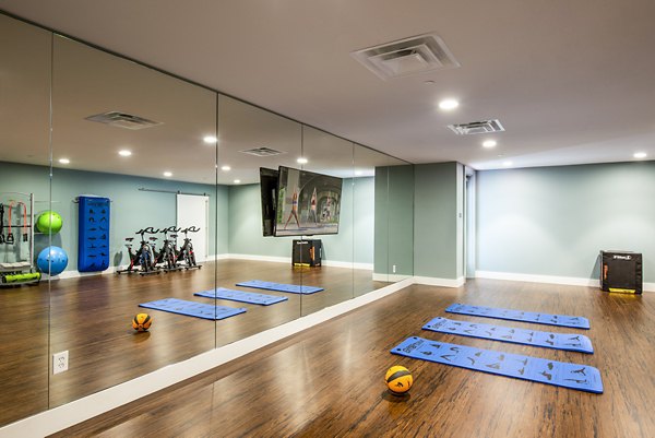 Yoga and spin studio at Brookland Press Apartments featuring modern fitness equipment and vibrant design
