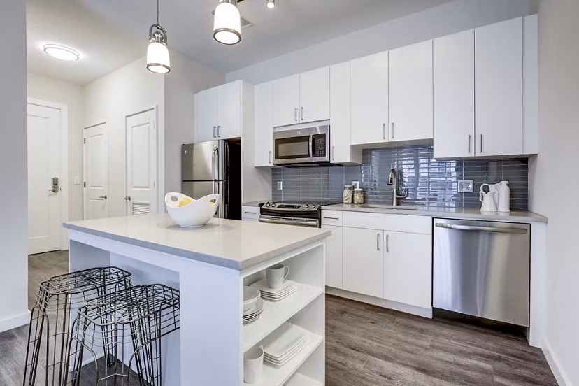 Modern kitchen featuring sleek appliances and marble countertops in Brookland Press Apartments
