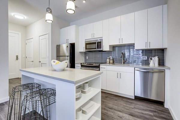 Modern kitchen featuring sleek appliances and marble countertops in Brookland Press Apartments