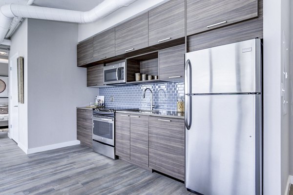 Modern kitchen with stainless steel appliances and sleek countertops at Brookland Press Apartments