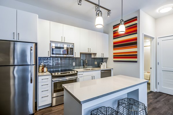 Modern kitchen featuring stainless steel appliances and quartz countertops at Brookland Press Apartments
