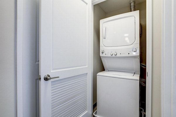 Laundry room with modern appliances at Brookland Press Apartments, luxury living with premier amenities in a stylish community