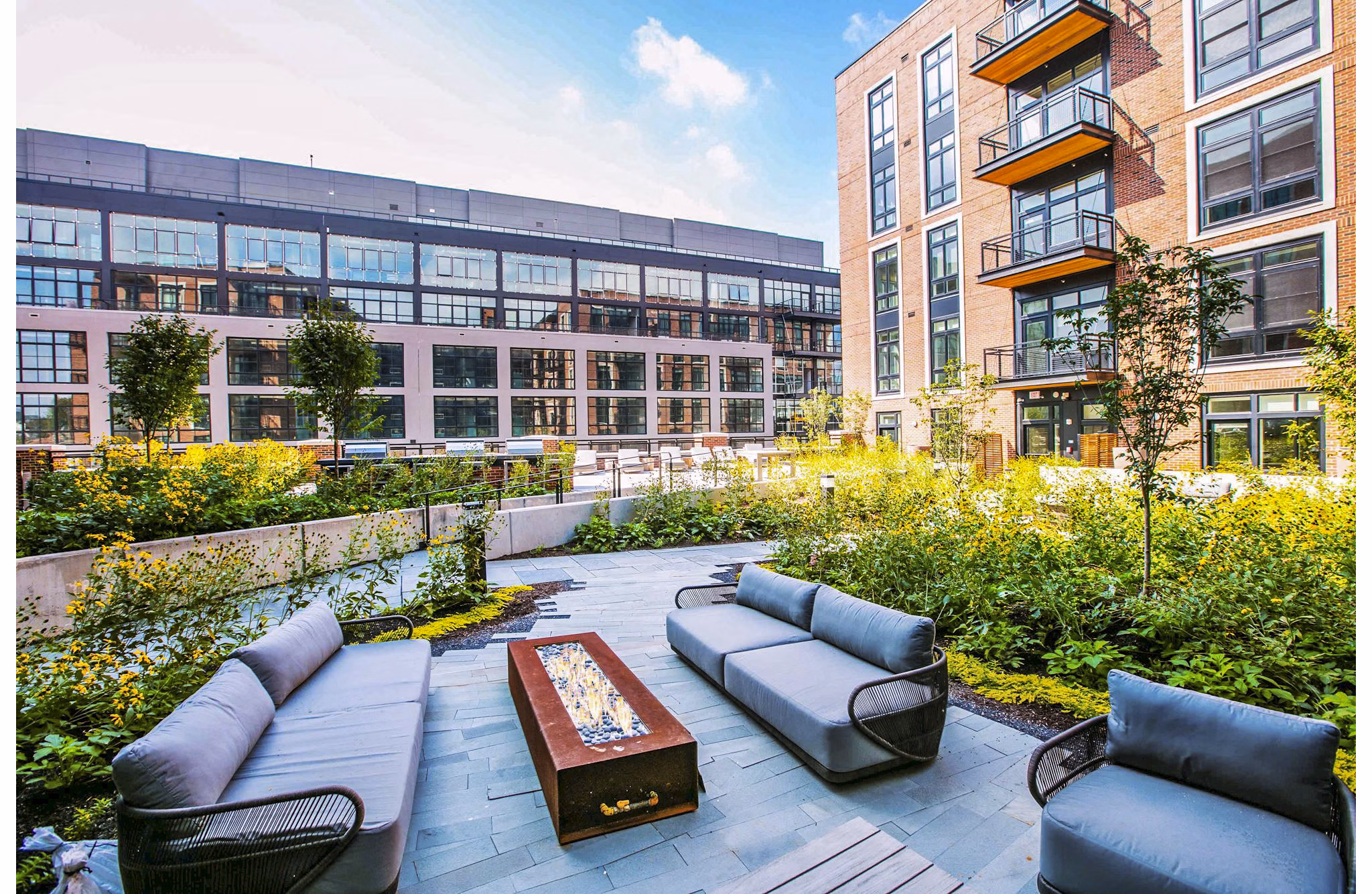 Cozy patio with fire pit on balcony at Brookland Press Apartments, a luxury Greystar property featuring outdoor relaxation spaces