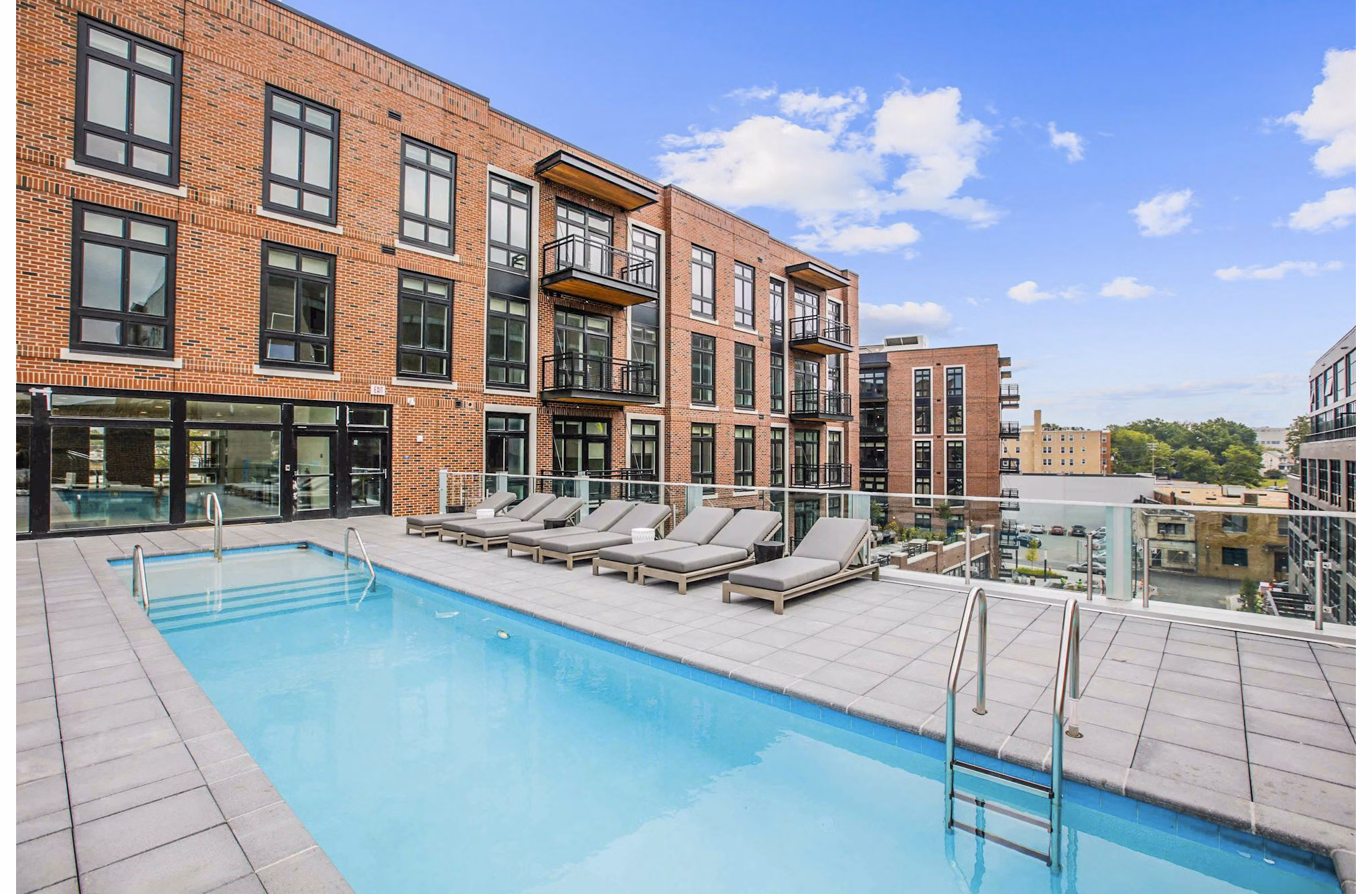 Rooftop pool with lounge seating at Brookland Press Apartments