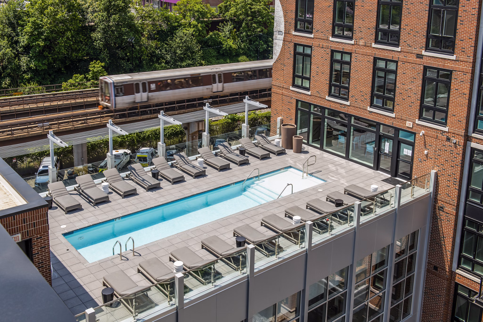 Modern swimming pool at Brookland Press Apartments with comfortable lounging areas