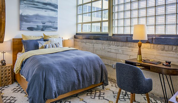 Cozy bedroom with chic decor at Hecht Warehouse Apartments in urban setting