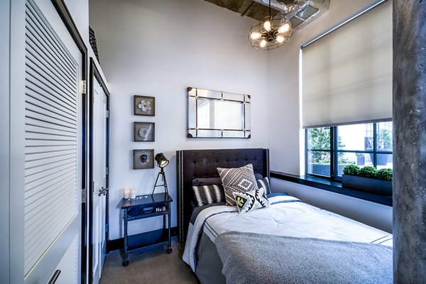 Spacious bedroom with urban decor at Hecht Warehouse Apartments, featuring luxury amenities and modern design