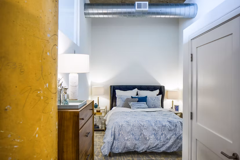 Cozy bedroom with industrial design elements at Hecht Warehouse Apartments
