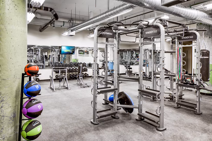 Modern fitness center with state-of-the-art equipment at Hecht Warehouse Apartments, featuring spacious workout areas