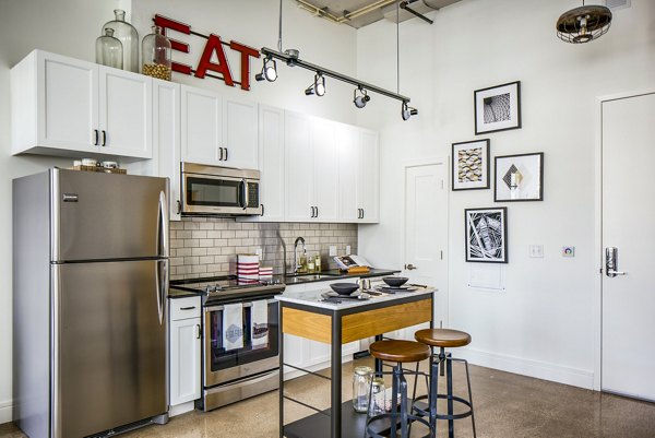 Kitchen featuring modern appliances and granite countertops in Hecht Warehouse Apartments