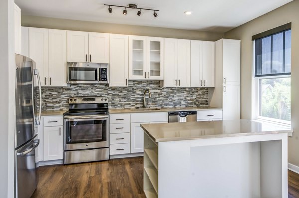 Modern kitchen with stainless steel appliances at Willow & Maple Apartments