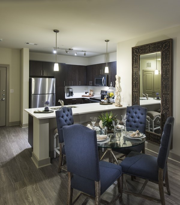 Dining room featuring elegant wooden dining set and modern lighting at The Landing at Vinnin Square Apartments