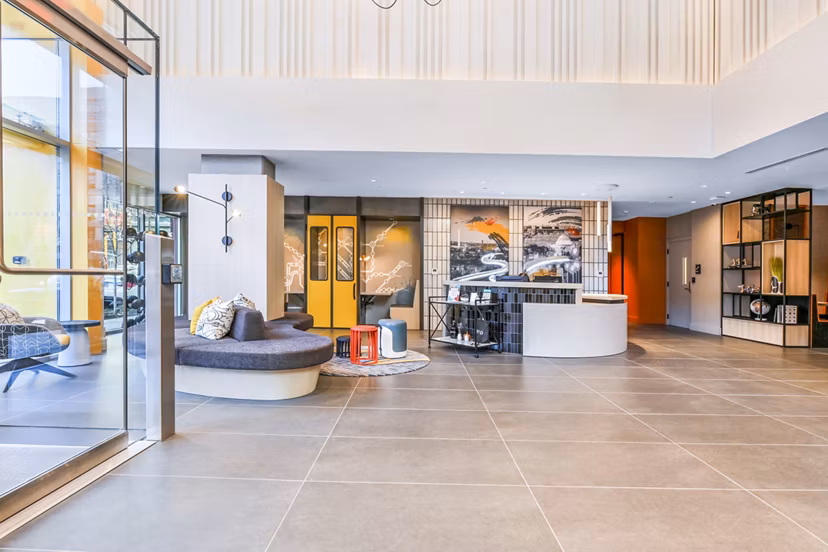 Clubhouse lobby with modern decor and seating area at SoNYa Apartments