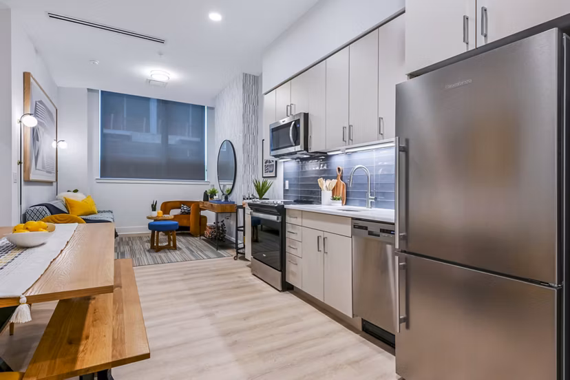 Modern kitchen featuring stainless steel appliances and sleek countertops in SoNYa Apartments