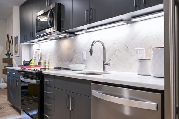 Modern kitchen featuring stainless steel appliances and sleek cabinetry at SoNYa Apartments in New York City