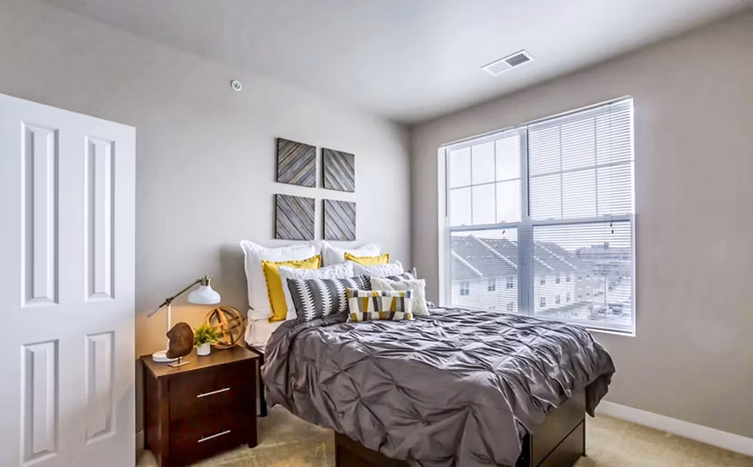 Cozy bedroom with comfortable queen-sized bed and modern decor at The Langston Apartments, perfect for a luxury living experience
