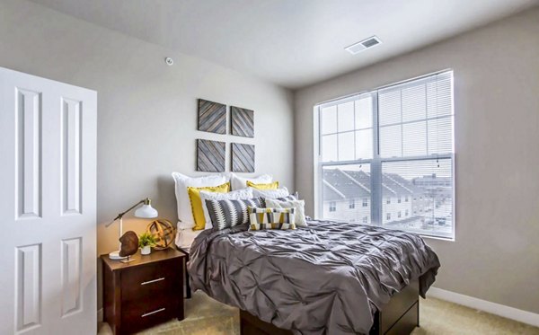 Cozy bedroom with comfortable queen-sized bed and modern decor at The Langston Apartments, perfect for a luxury living experience