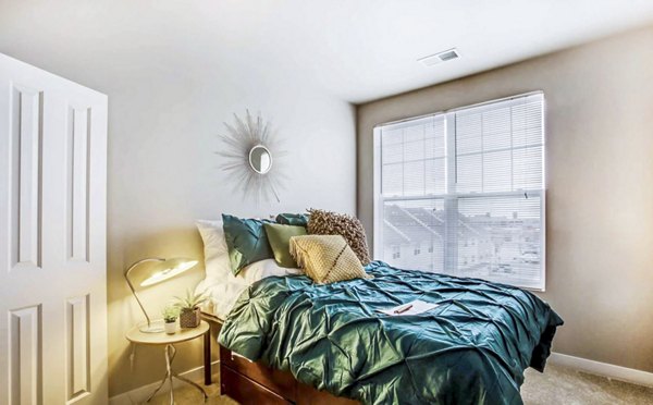 Cozy bedroom with modern decor in The Langston Apartments, offering a serene living space in luxury Greystar community
