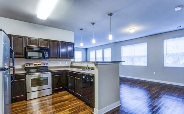 Modern kitchen with stainless steel appliances and island counter at The Langston Apartments, ideal for luxury urban living