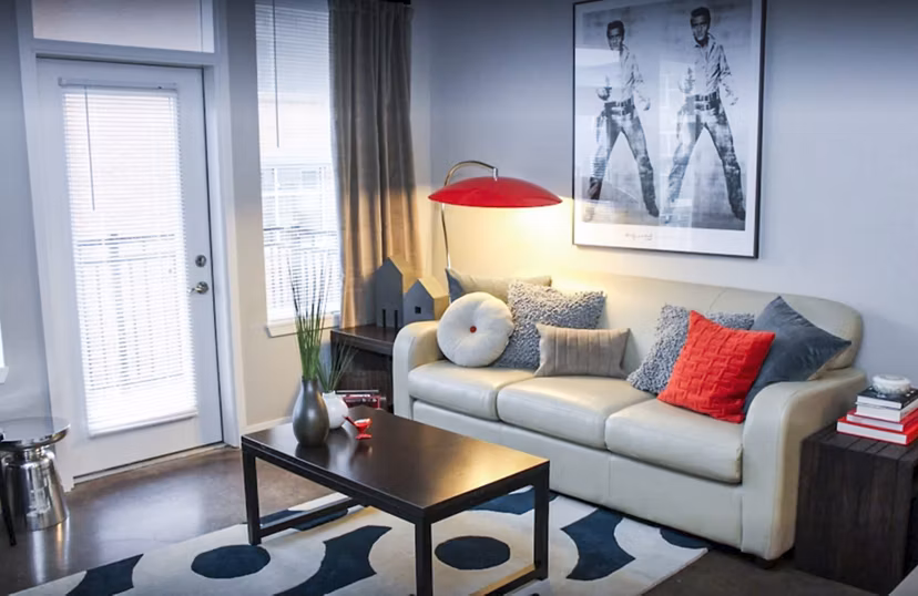 Bright living room with modern furnishings and city views at The Langston Apartments
