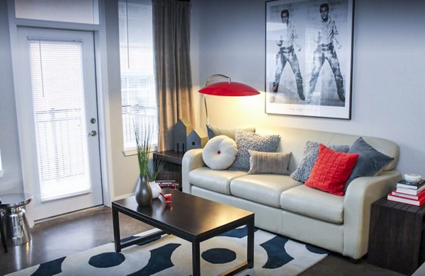 Bright living room with modern furnishings and city views at The Langston Apartments