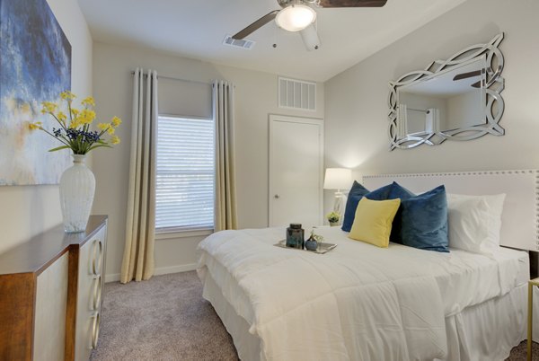 Bedroom with modern decor and ample natural light in Roots at O'Connor Apartments