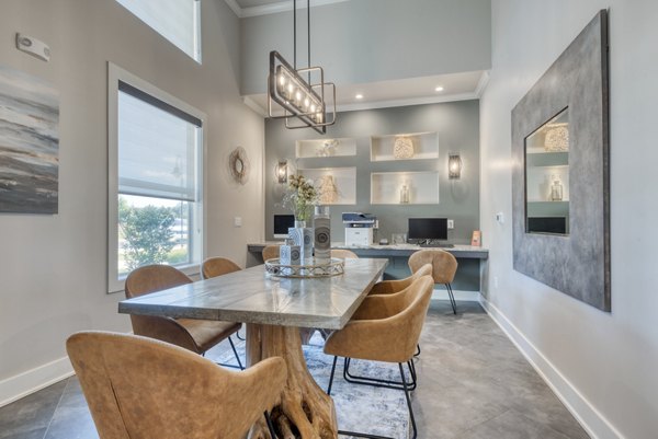 Business center with modern workstations at Roots at O'Connor Apartments, ideal for remote working and collaboration in a luxury setting