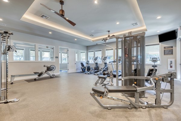 State-of-the-art fitness center with modern equipment at Roots at O'Connor Apartments, designed for active living and wellness enthusiasts