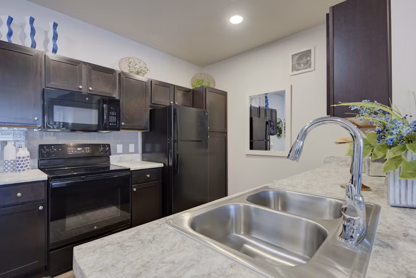 Modern kitchen with stainless steel appliances at Roots at O'Connor Apartments