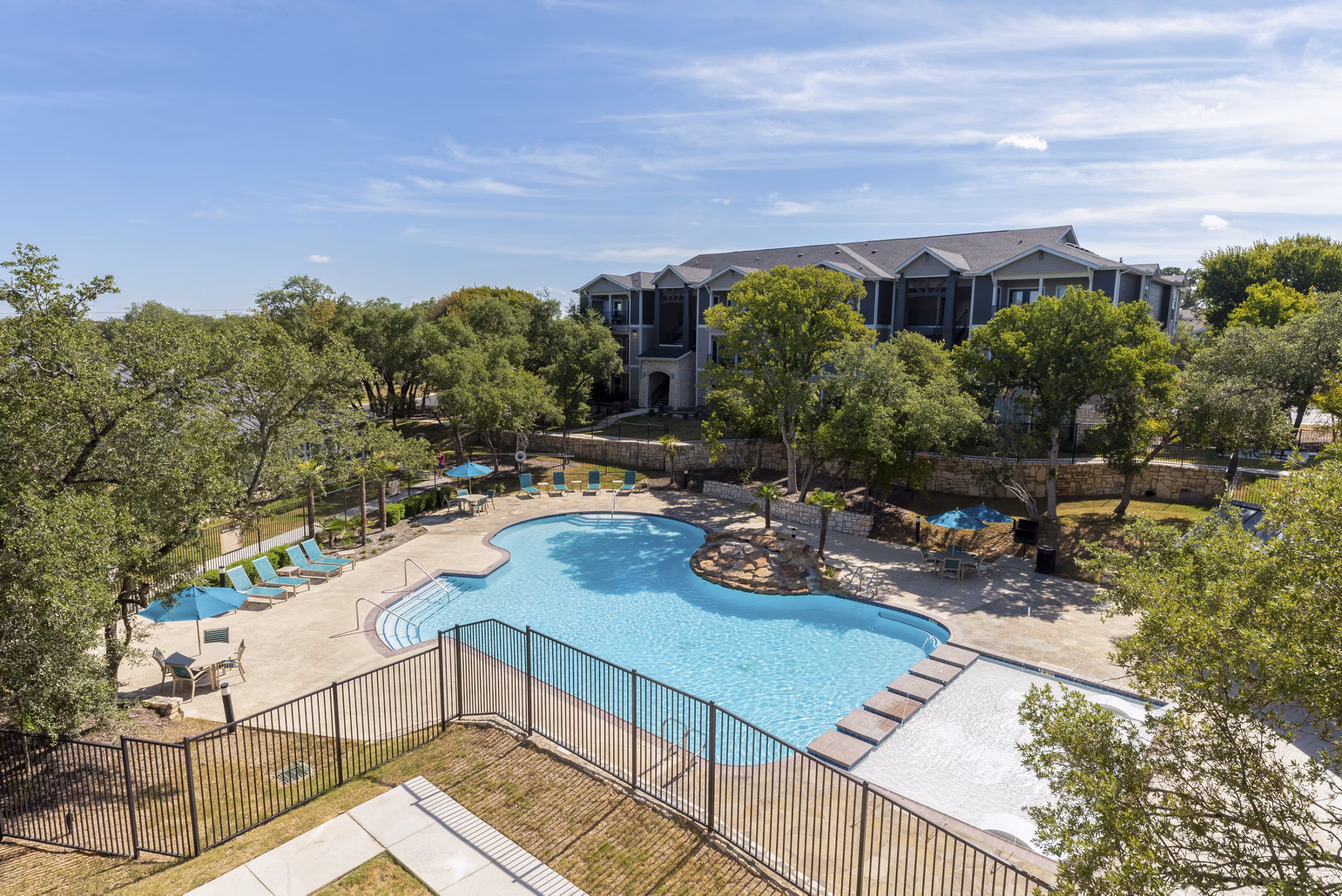 Pool with surrounding deck and loungers at Roots at O'Connor Apartments