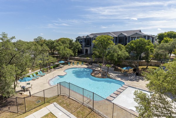 Pool with surrounding deck and loungers at Roots at O'Connor Apartments
