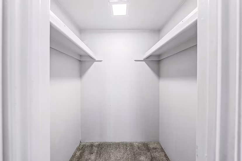 Walk-in closet with ample shelving space in Villatree Apartments bedroom