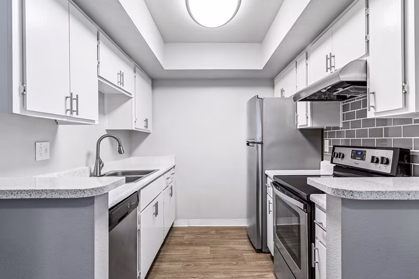 Modern kitchen featuring sleek cabinetry and stainless steel appliances in Villatree Apartments