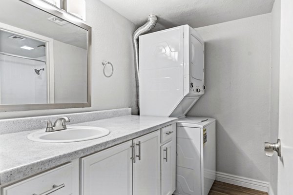 Bath and laundry room with modern fixtures and ample storage in Villatree Apartments