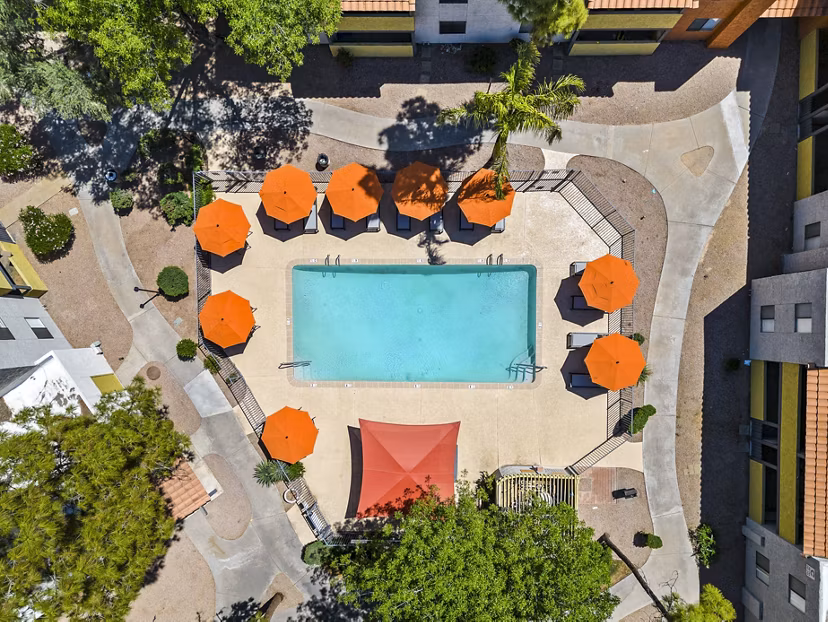 Relaxing pool area with lounge chairs and umbrellas at Villatree Apartments